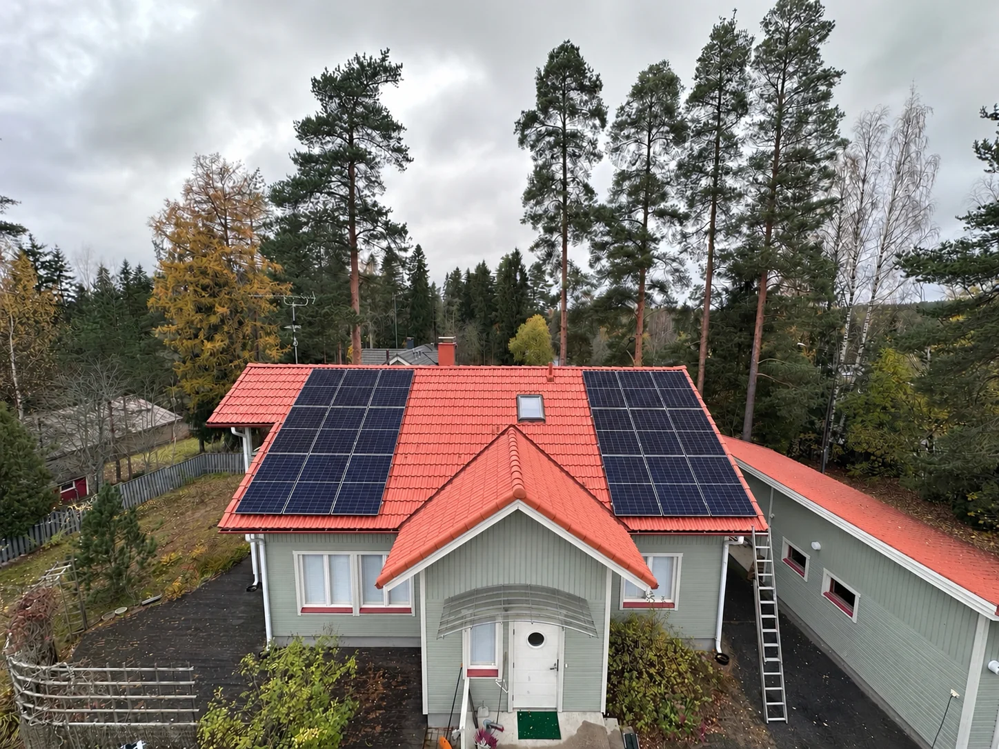 8,28&nbsp;kWp aurinkopaneelisto omakotitalon punaisella tiilikatolla kahdessa paneeliryhmässä