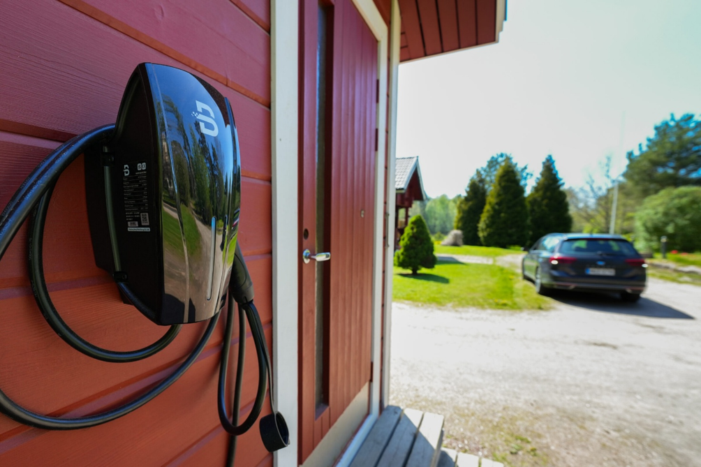 Sähköauton latausasema asennettuna omakotitalon seinään